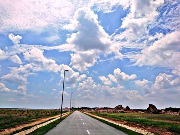 Road passing through land against sky