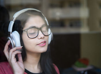 Close-up of young woman listening music