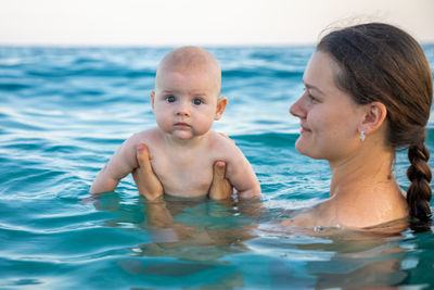 Portrait of cute girl with mother in sea