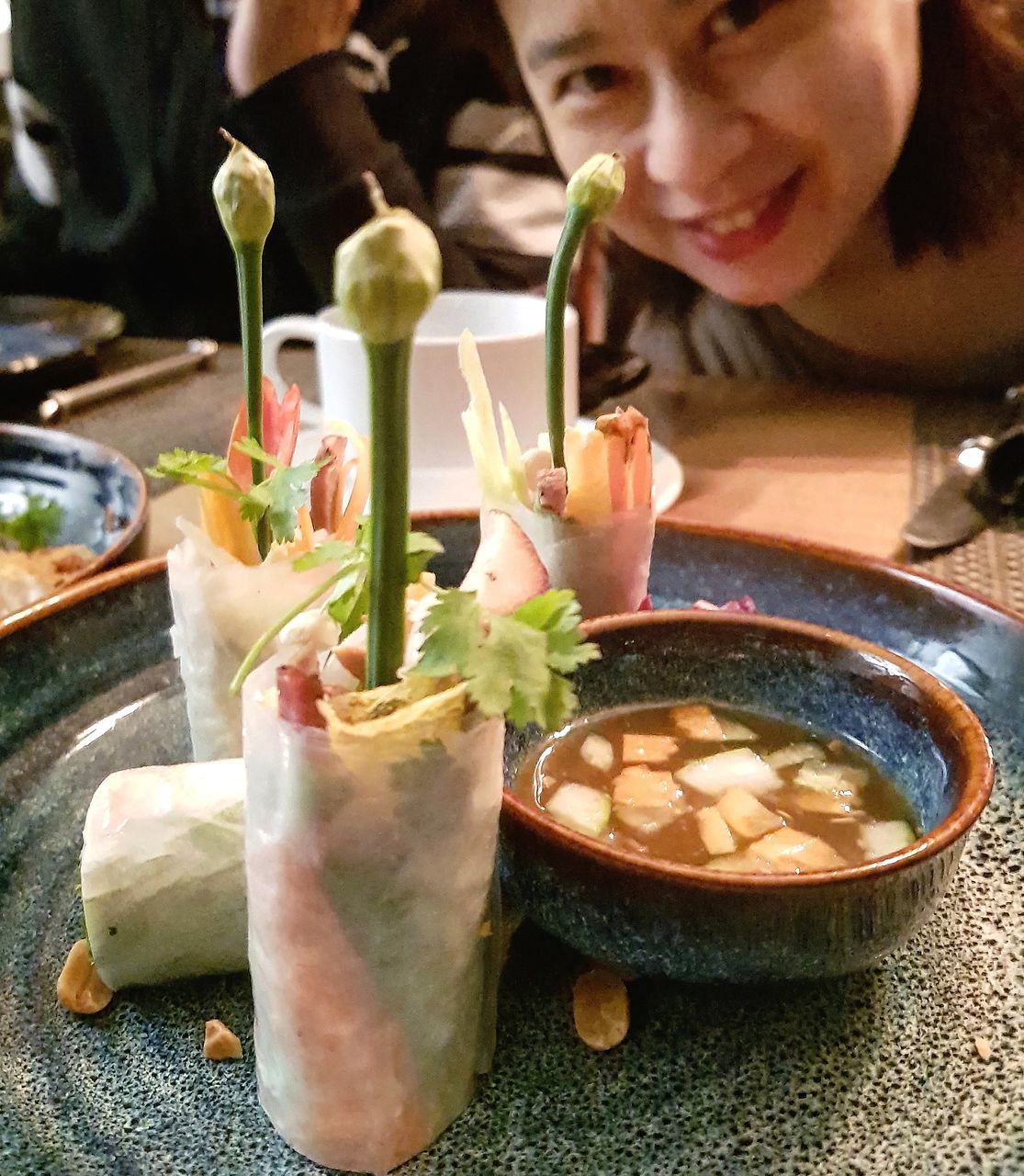 food and drink, food, freshness, one person, indoors, holding, lifestyles, real people, table, sitting, women, ready-to-eat, business, bowl, restaurant, close-up, focus on foreground, leisure activity, wellbeing, glass