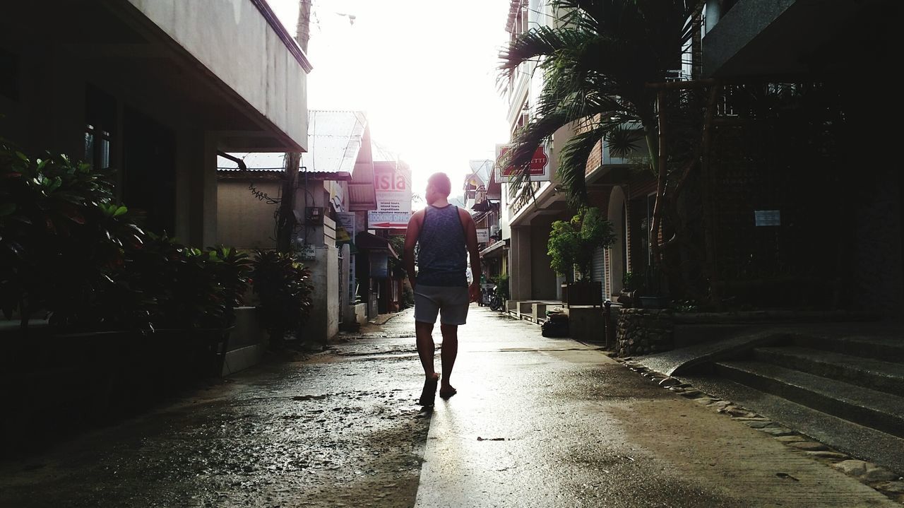 REAR VIEW OF MEN WALKING IN CITY