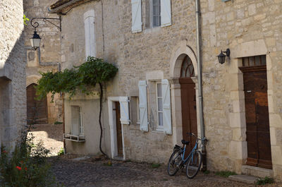 Bicycle on alley amidst buildings in city