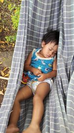 High angle view of girl sleeping on hammock