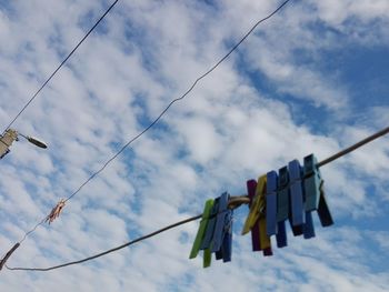 Low angle view of clothes hanging on clothesline against sky