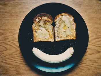 High angle view of toasted breads with banana served in plate on table