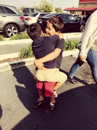 Rear view of friends standing on street in city