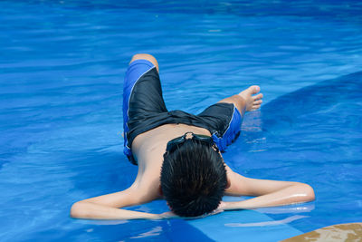 Rear view of woman swimming in pool