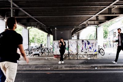 Rear view of woman walking on bridge in city