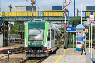 Man standing by train at railroad station