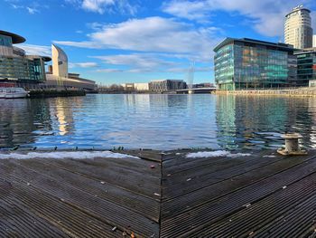 Pier by lake against sky in city