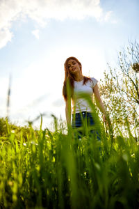 Portrait of young woman standing amidst plants