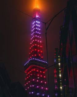 Low angle view of illuminated buildings against sky at night