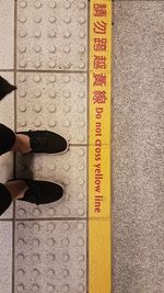 Low section of man standing on tiled floor