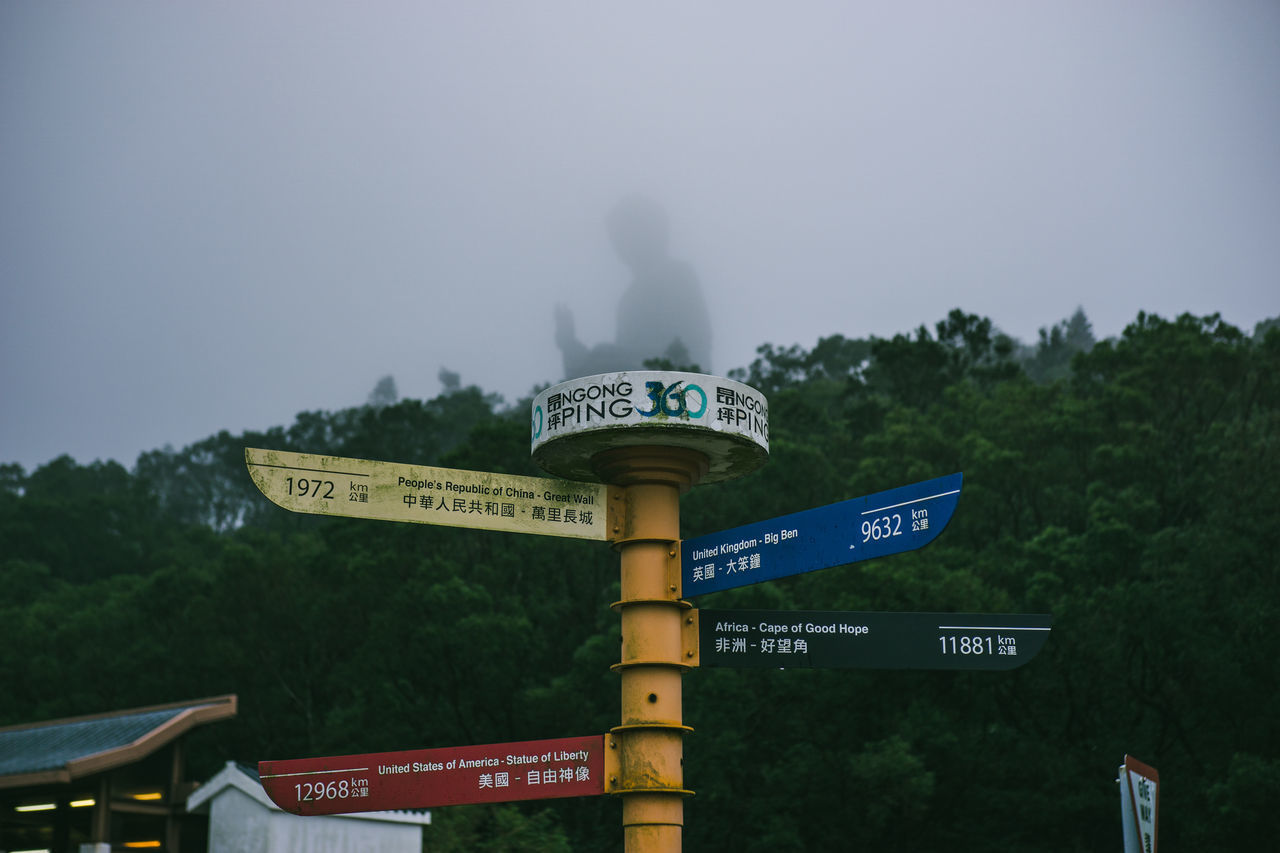 INFORMATION SIGN AGAINST TREES AND SKY