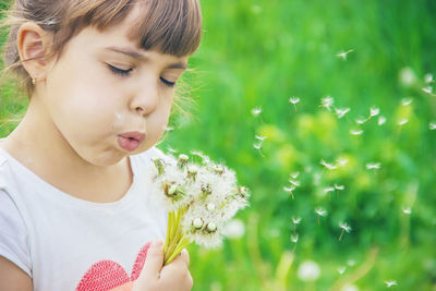 Close-up of boy blowing flowers