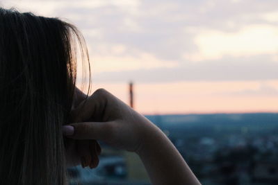 Rear view of woman against sky during sunset