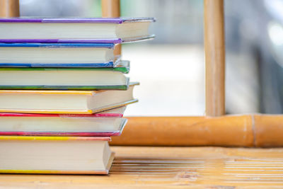 Stack of colorful books on wooden table