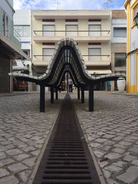 Footpath amidst buildings in city