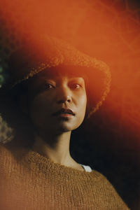 Portrait of woman in brown hood at illuminated bar