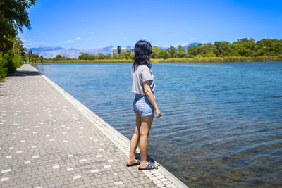 Full length of young woman standing in lake