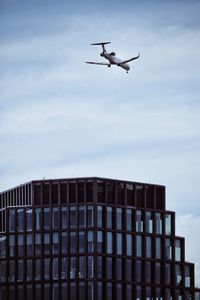 Low angle view of airplane flying against sky