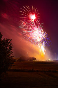 Low angle view of firework display at sunset