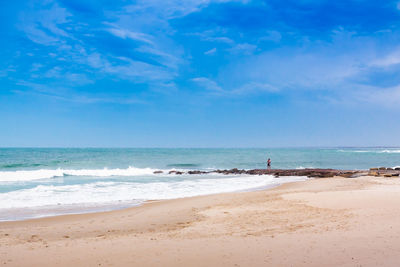 Scenic view of beach against blue sky