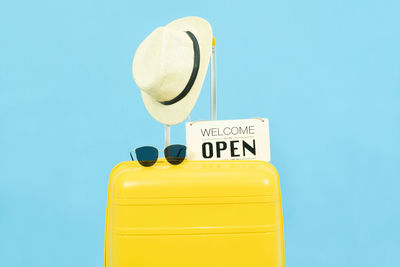 Low angle view of yellow bottle against blue background