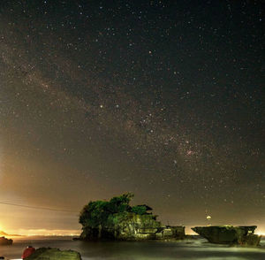 Scenic view of sea against star field at night