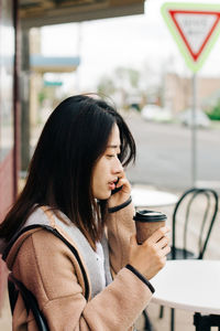 Close-up of woman drinking coffee at cafe
