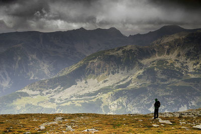 Man standing on mountain against sky