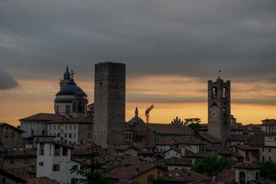 Buildings in city against sky during sunset