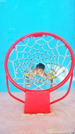 Low angle view of boy playing with ball against blue background