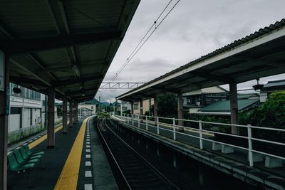 Railroad platform and tracks against overcast sky