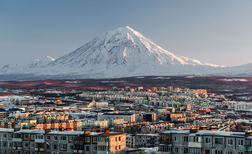 High angle view of cityscape against snow covered mountains