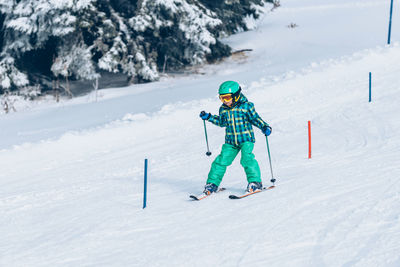 Boy skiing on snow covered land