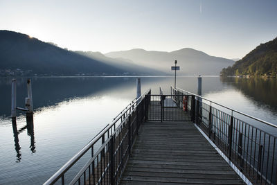 Pier over lake against clear sky