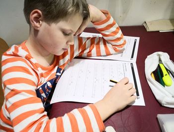 High angle view of boy sitting on book