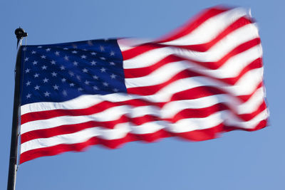 Low angle view of flag against blue sky