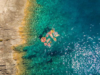 Aerial view of people relaxing on sea during sunny day