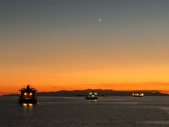 View of ships over sea against sky during sunset