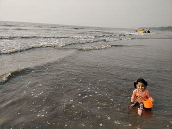 People in sea against sky