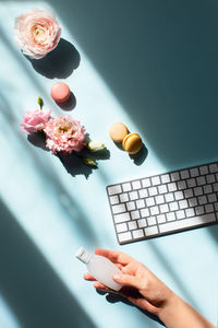 Flowers and macaroons in sunlight and with a sanitizer on a women hand. 
