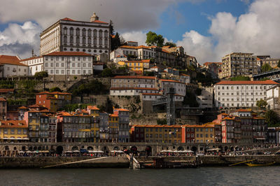 Buildings by sea against sky in city