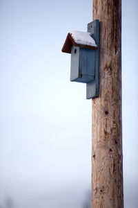 Low angle view of wooden post against sky