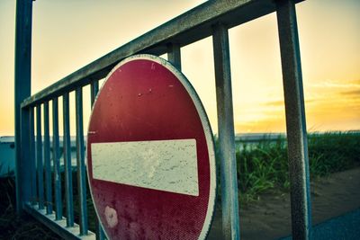 Close-up of road sign on railing