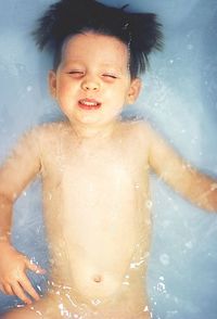Directly above shot of shirtless boy in bathtub