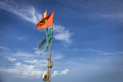 Low angle view of flags on pole against sky