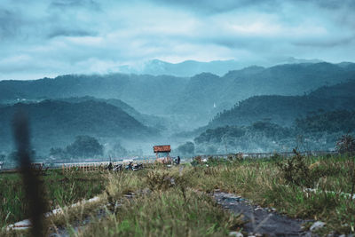 Scenic view of land and mountains against sky