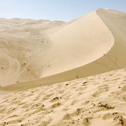 Scenic view of sand dunes against clear sky